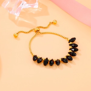 Golden adjustable pull chain bracelet with black teardrop beads and metal spheres