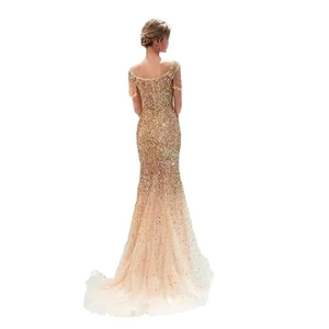 Dettaglio dell'abito da sera con paillettes champagne, spalline a frange e bordo a sirena