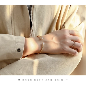 Chic 18K gold-plated cuff bracelet featuring dual white zircons on a model's wrist