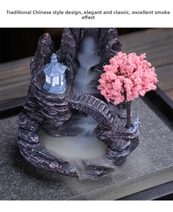 Macro view of a resin backflow incense burner featuring a blue pavilion and pink tree