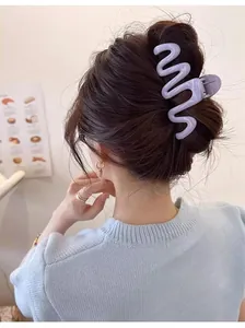 Detailed back view of a woman wearing a purple wavy hair claw clip for a secure bun hairstyle