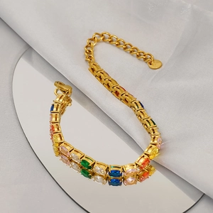 Bracciale tennis dorato lucido con pietre ovali multicolore su sfondo di seta