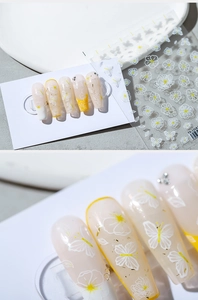 Vue macro de stickers ongles floraux fins avec fleurs blanches et détails en feuille d'or