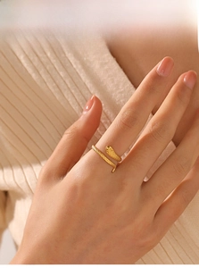 Close-up of golden snake ring with scale texture worn by a model on hand