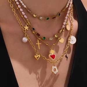 Mehrlagige Goldkette mit bunten Zirkonia-Anhängern, Herzanhängern und Perlen am Model