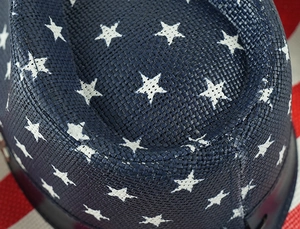 Détail macro du chapeau de paille cowboy avec étoiles blanches et texture style drapeau US