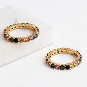 Detailed shot of two gold rainbow eternity rings with multi-color zircon stones