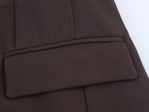 Close-up of dark brown blazer pocket showing fine woven texture and precise stitching