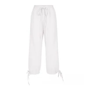 Detail of adjustable drawstring cuffs and elastic waist on white cotton linen pants