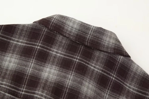 Detail view of the classic black and gray plaid shirt collar and flannel fabric texture