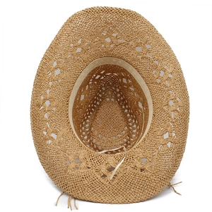 Detailed close-up of hollow out woven pattern and sweatband on a straw cowboy hat