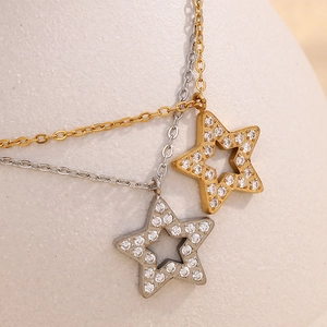 Detailed macro view of gold and silver star pendants with sparkling cubic zirconia inlay