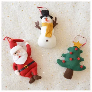 Detailed view of red and white Santa, Snowman, and Christmas tree plush ornaments