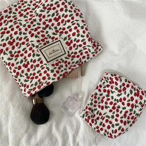 Macro detail of cherry print pleated cosmetic bag with zipper and Pleasant Time label