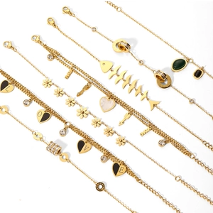 Close-up of gold chain bracelets with charms including hearts, pearls, and crystals