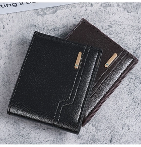 Detail of short leather wallets showing litchi texture and gold metal accents