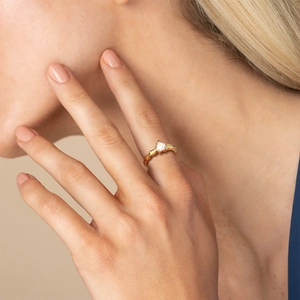 Golden stainless steel ring with textured band and heart-shaped white zircon on finger