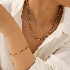 Two-tone gold and silver stainless steel chain necklace and bracelet set on a model