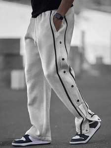 Detail of men's light grey jogger featuring side black stripes and snap button closures