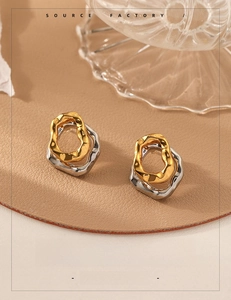 Detailed view of two-tone gold and silver irregular wavy earrings with lava texture finish