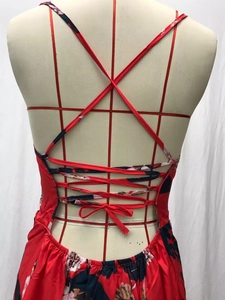 Detail of red floral maxi dress showing crisscross spaghetti straps and lace-up back