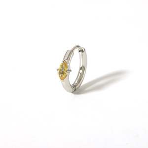 Macro view of silver huggie earring featuring a yellow marquise-cut zircon gemstone