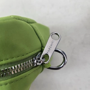 Detail of silver PARCHITA zipper and D-ring on green nylon crossbody bag