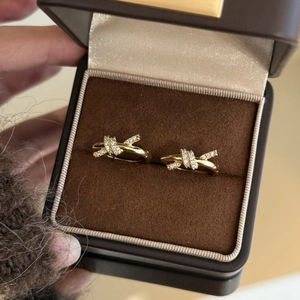 Gros plan de boucles d'oreilles nœud plaquées or avec zircons sur coffret velours