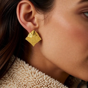 Detailed view of gold plated square mesh earrings on a model showing fine texture