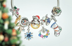 Macro shot of silver Christmas charm bracelet with snowflake and stocking pendants