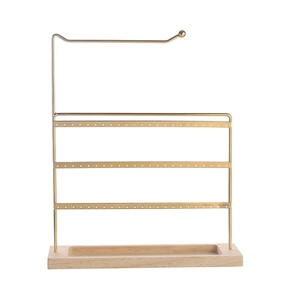 Detail view of gold iron earring organizer with multi-tier rods and wooden base