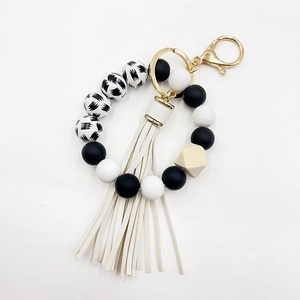 Close-up of silicone beads and wooden hexagon bead on a tassel keychain with gold clasp
