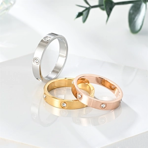 Close-up of three titanium steel rings in silver gold and rose gold with inlaid rhinestones