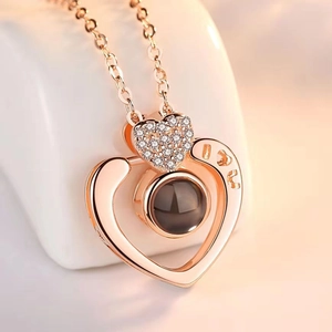 Close-up of rose gold double heart necklace with a micro-engraved 100 languages projection stone