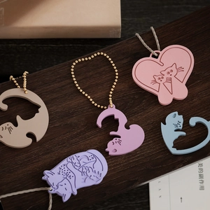 Macro shot of colorful cat-shaped resin pendants with heart patterns on wooden surface