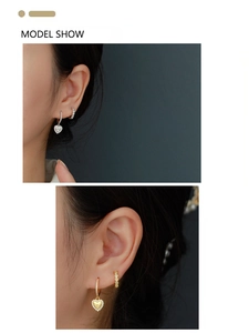 Close-up of gold and silver heart-shaped diamond earrings on model ear model show