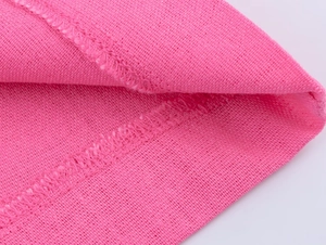 Gros plan sur la texture du lin rose avec couture surjetée détaillée et fini doux