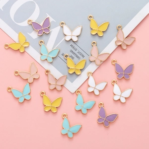 Flat lay of colorful enamel butterfly charms in pastel colors with gold alloy plating