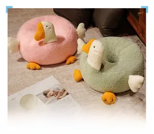 Detail of goose plush floor cushions in pink and green with soft textured fabric