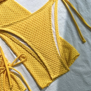 Dettaglio bikini giallo brillante con trama a nido d'ape e tessuto elastico di qualità
