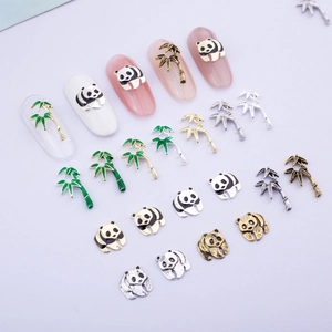 Detail of 3D metal panda and bamboo nail charms in silver and gold with enamel finish