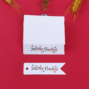 Dettaglio di etichette natalizie bianche a forma di bandiera con stampa Merry Christmas e renna