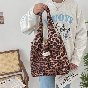 Detailed close-up of leopard print canvas tote bag featuring branded woven label and texture