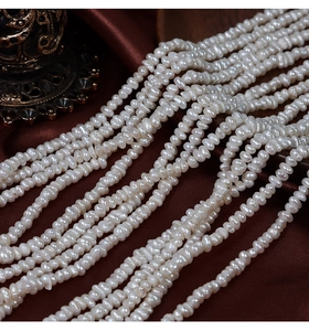 Détail macro de perles d'eau douce naturelles irrégulières sur satin marron foncé