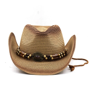 Detail of woven straw cowboy hat with beaded band and decorative turquoise medallion