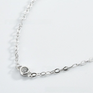 Macro detail of S925 sterling silver chain featuring a round brilliant zircon pendant