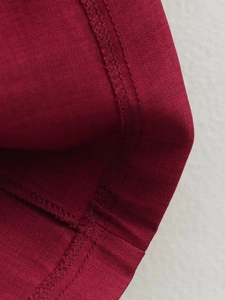 Macro shot of dark red fabric texture showing high-quality stitching and woven detail
