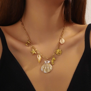 18K gold plated ocean shell necklace with starfish and seahorse charms on a model
