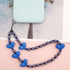 Blue acrylic heart phone charm with striped beads attached to a smartphone