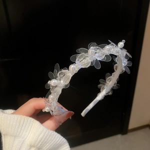 Close-up of beaded headband with transparent flower petals and white faux pearls